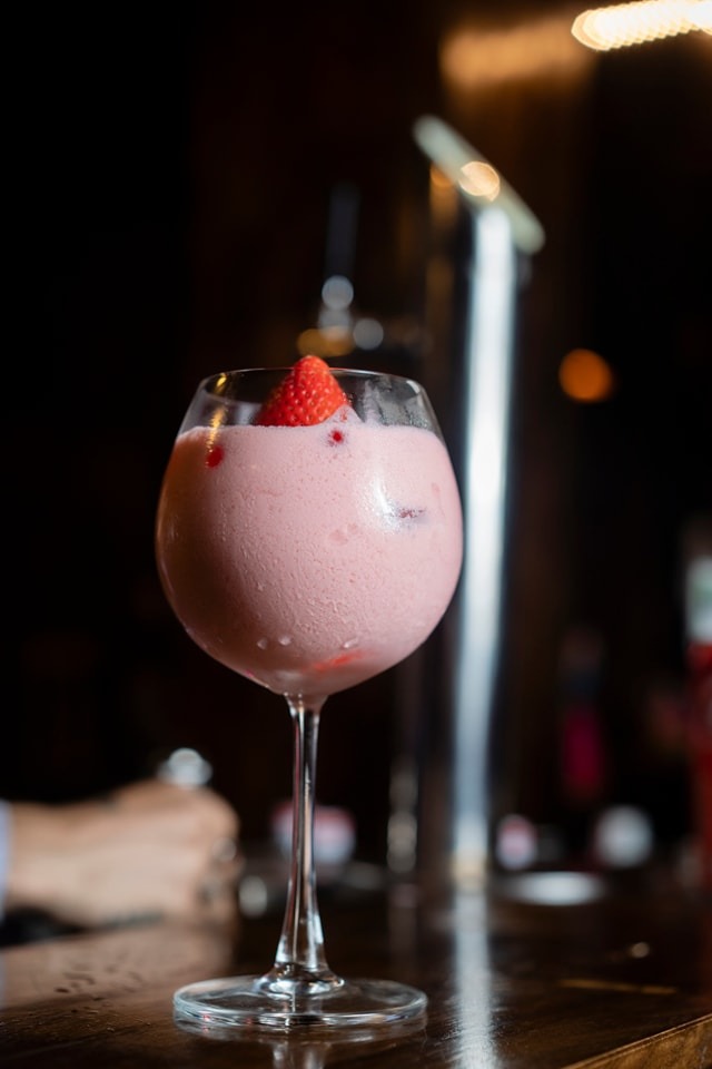 Beverage hero shot of a pink cocktail styled for a minimal, premium look