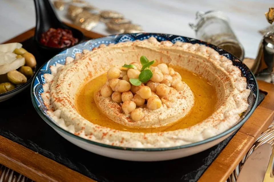 Food photography of a hummus platter styled for a clean, editorial presentation