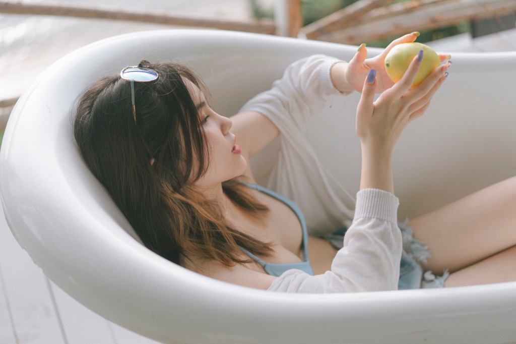 Lifestyle wellness scene with a relaxing bathtub setting and mango accents in a minimal style