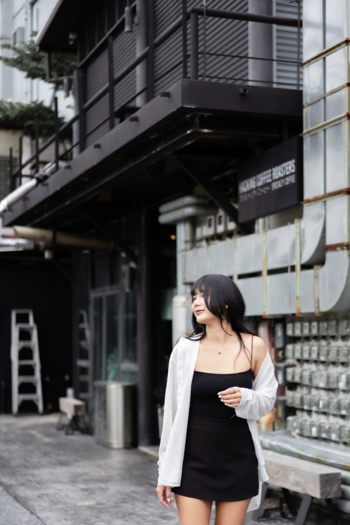 Outdoor urban editorial portrait featuring a subject in a black dress with moody styling