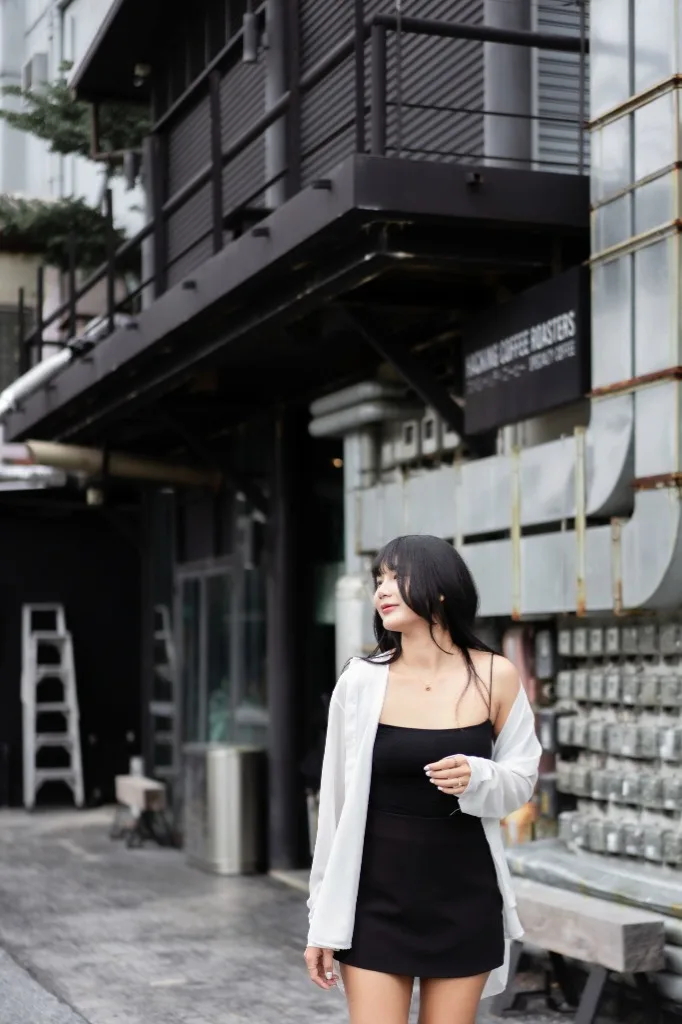Outdoor urban editorial portrait featuring a subject in a black dress with moody styling