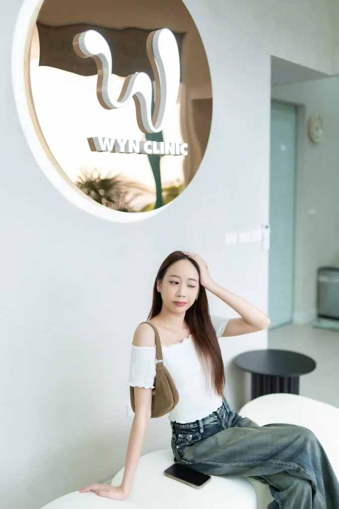 Wellness portrait of a woman in a spa clinic setting with soft, minimal lighting